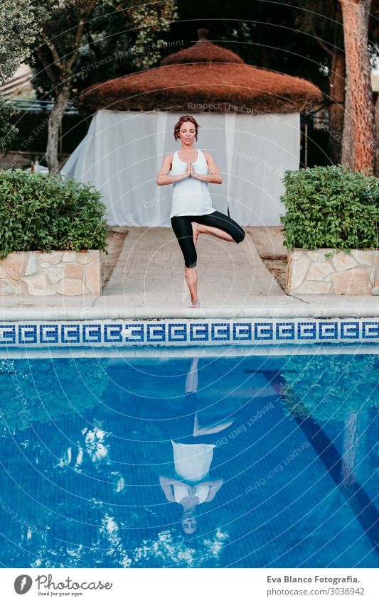 Frau, die Yoga am Swimmingpool macht. Yoga und Achtsamkeit Lifestyle schön Körper Erholung ruhig Meditation Spa Schwimmbad Freizeit & Hobby