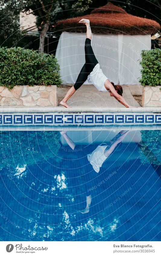 Frau, die Yoga am Swimmingpool macht. Yoga und Achtsamkeit Lifestyle schön Körper Erholung ruhig Meditation Spa Schwimmbad Freizeit & Hobby