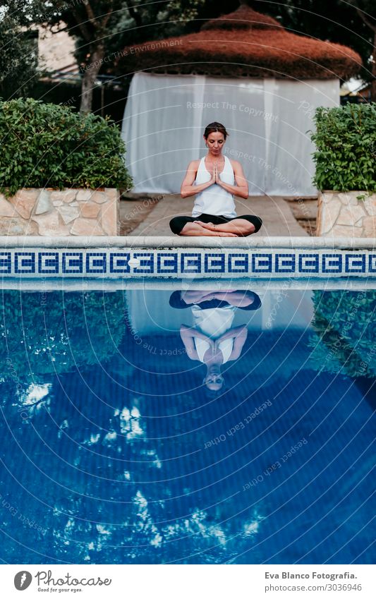 Frau, die Yoga am Swimmingpool macht. Yoga und Achtsamkeit Lifestyle schön Körper Erholung ruhig Meditation Spa Schwimmbad Freizeit & Hobby