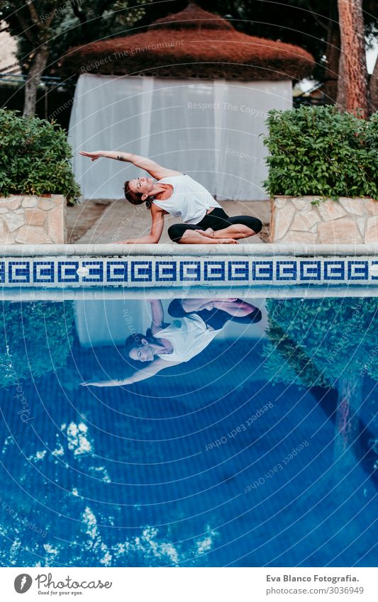 Frau, die Yoga am Swimmingpool macht. Yoga und Achtsamkeit Lifestyle schön Körper Erholung ruhig Meditation Spa Schwimmbad Ferien & Urlaub & Reisen Sommer Sonne