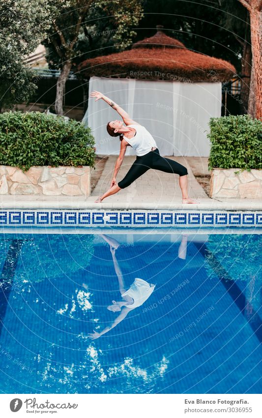 Frau, die Yoga am Swimmingpool macht. Yoga und Achtsamkeit Lifestyle schön Körper Erholung ruhig Meditation Spa Schwimmbad Ferien & Urlaub & Reisen Sommer Sonne