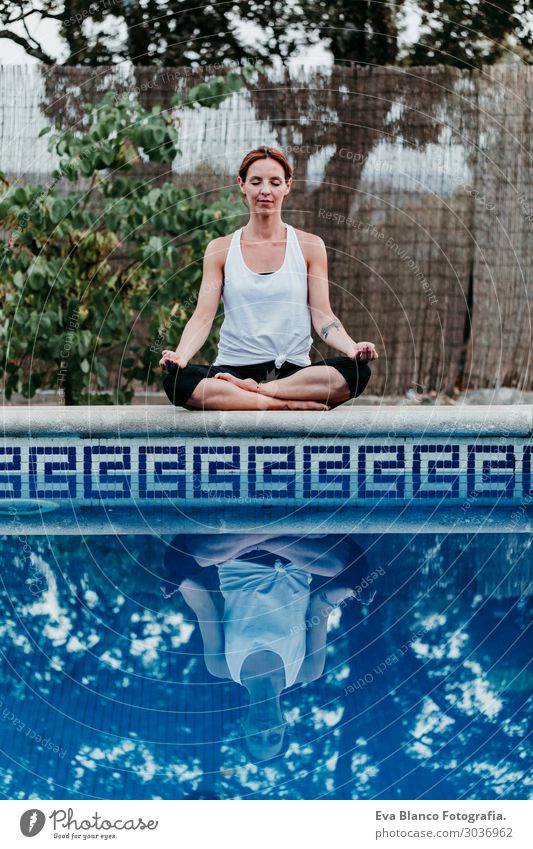 Frau, die Yoga am Swimmingpool macht. Yoga und Achtsamkeit Lifestyle schön Körper Erholung ruhig Meditation Spa Schwimmbad Ferien & Urlaub & Reisen Sommer Sonne