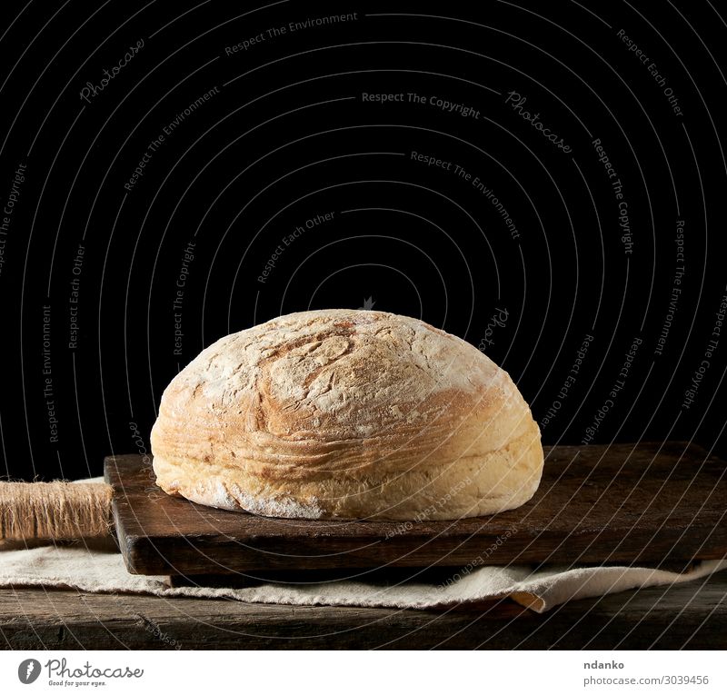 gebackenes rundes weißes Weizenbrot auf einem Textiltuch Brot Brötchen Ernährung Essen Frühstück Abendessen Tisch Küche Holz alt dunkel frisch natürlich braun