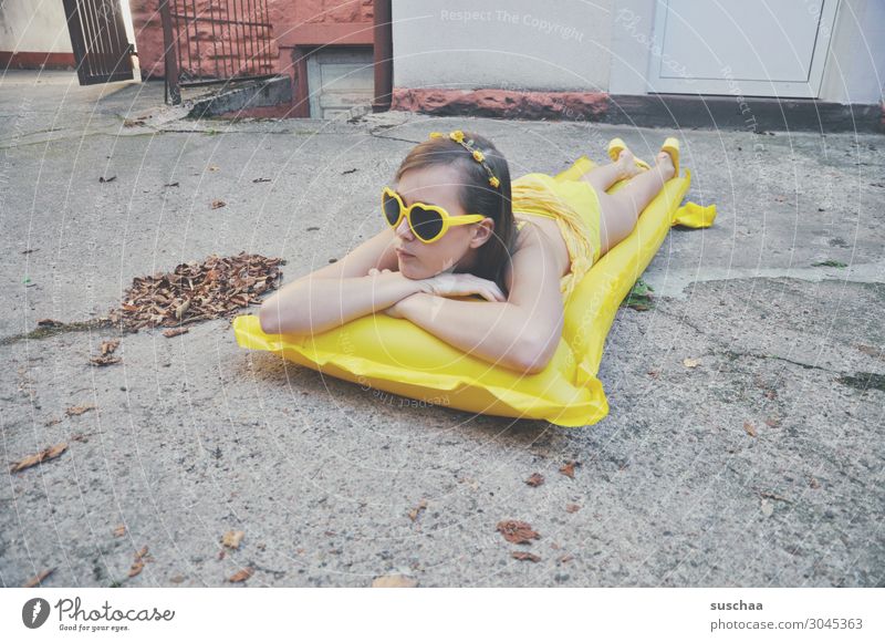 mädchen auf einer gelben luftmatratze im grauen hinterhof Sommer Herbst Blatt Sehnsucht Ferien & Urlaub & Reisen Schwimmen & Baden Luftmatratze Sonnenbrille