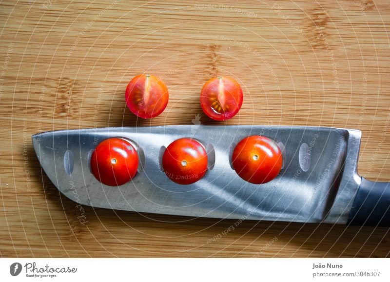 Geschnittene Kirschtomaten Gemüse Salat Salatbeilage Frucht Ernährung Mittagessen Abendessen Bioprodukte Vegetarische Ernährung Diät Besteck Messer Metall Stahl