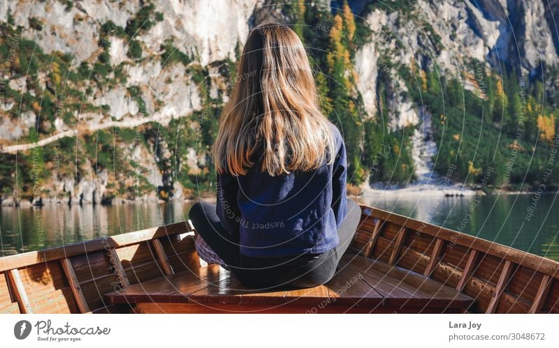 Girl from behind in wooden boat on mountain lake Ferien & Urlaub & Reisen Ausflug Abenteuer Ferne Expedition Berge u. Gebirge wandern feminin Mädchen Junge Frau