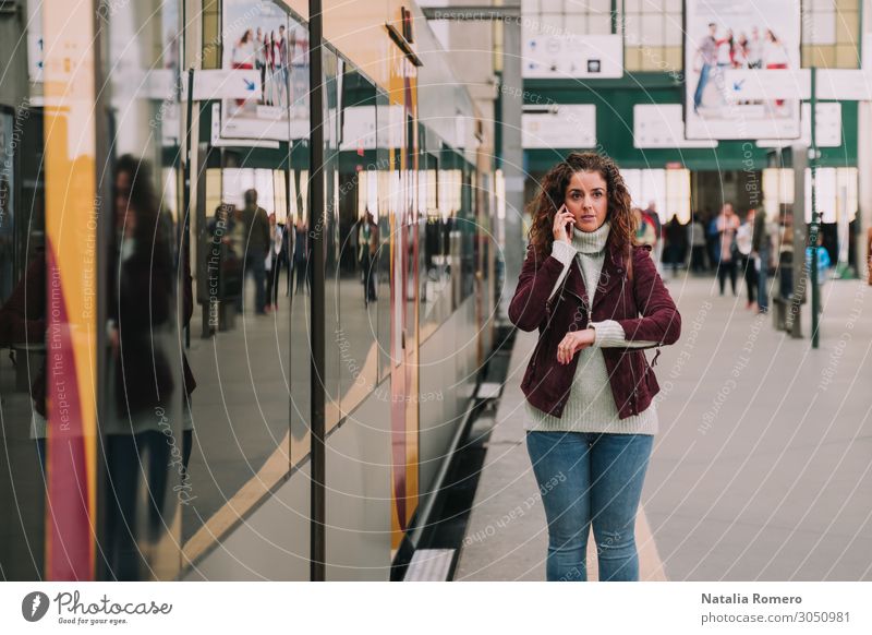 Die Frau telefoniert, während sie am Bahnhof ankommt. Lifestyle Glück schön Leben Ferien & Urlaub & Reisen Tourismus Ausflug Uhr Mensch Erwachsene Hand Verkehr