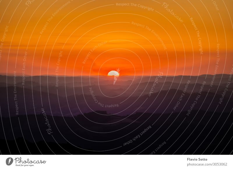 Ein sehr bunter Sonnenuntergang Umwelt Natur Landschaft Urelemente Himmel Wolkenloser Himmel Horizont Sonnenaufgang Sonnenlicht Baum Wald Hügel mehrfarbig gelb