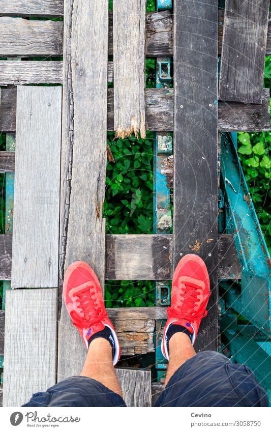 Watch your step! Brücke laufen Holz Holzbrücke Loch stolpern Stolperfalle bedrohlich gefährlich Absturz Absturzgefahr rot Schuhe Turnschuh Shorts Wade Fußtritt