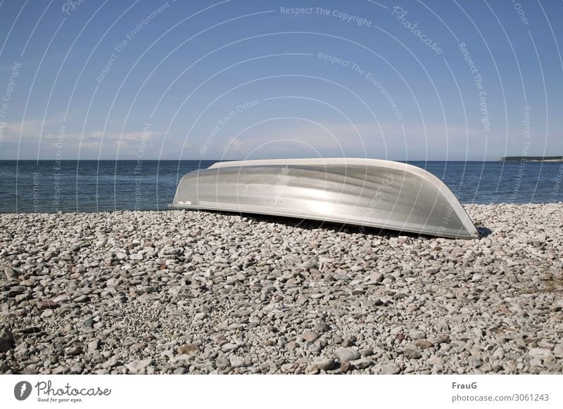 Aluminiumboot am Steinstrand Meer Ostsee Strand Küste Steine am Strand Kalksteine Boot Metall Sommer Himmel Wolken