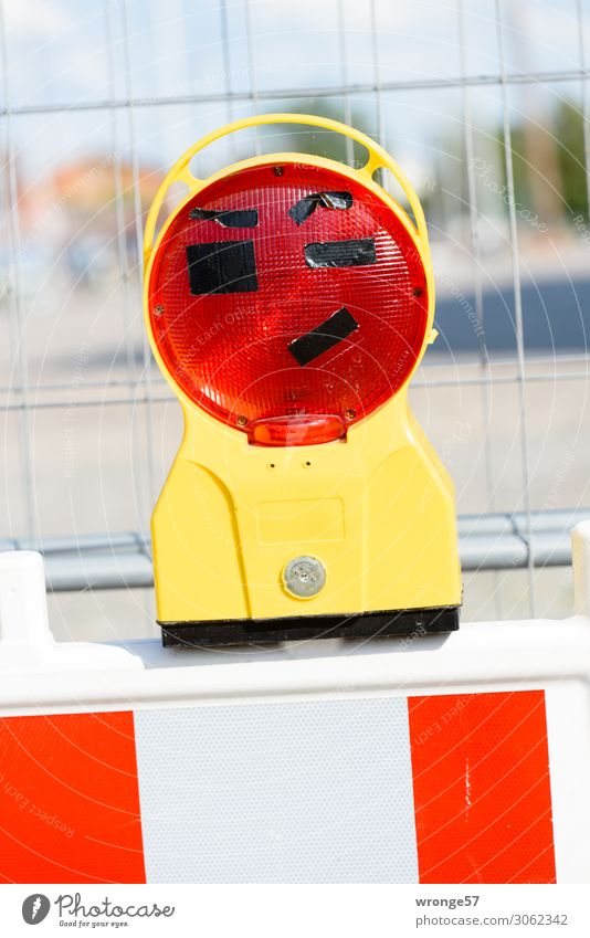 Spaßvogel I Lampe lustig nah gelb rot weiß Baustelle Absperrgitter Bauzaun Warnleuchte spaßig Freude Farbfoto mehrfarbig Außenaufnahme Nahaufnahme Menschenleer