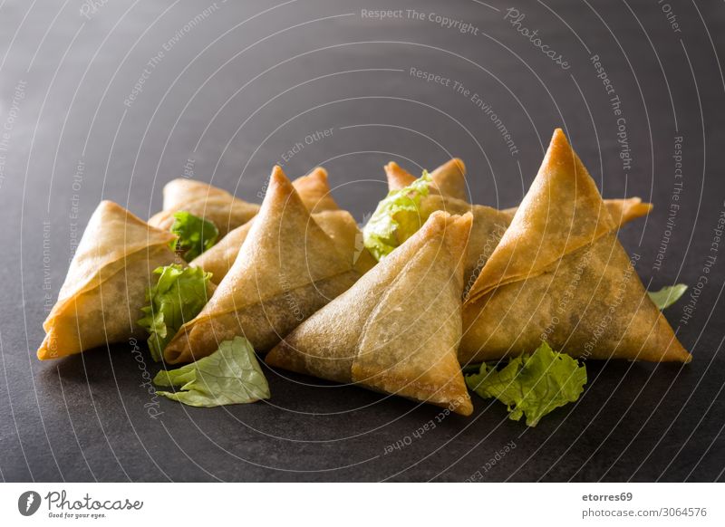 Samsa oder Samosas mit Fleisch und Gemüse auf schwarzem Hintergrund. Vegetarische Ernährung Lebensmittel Gesunde Ernährung Foodfotografie Inder Tradition