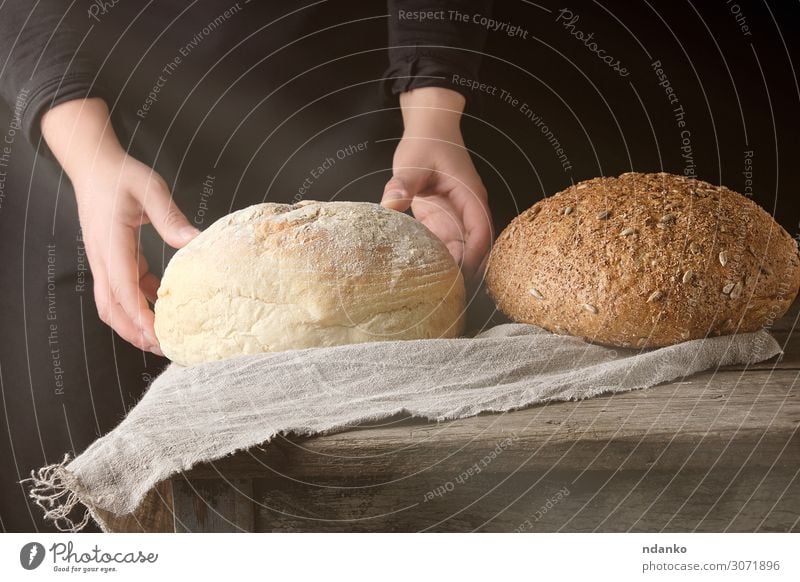 zwei weibliche Hände lagen auf einem Tisch, der mit weißem Rundbrot gebacken wurde. Teigwaren Backwaren Brot Frühstück Sonne Küche Mensch Frau Erwachsene Arme