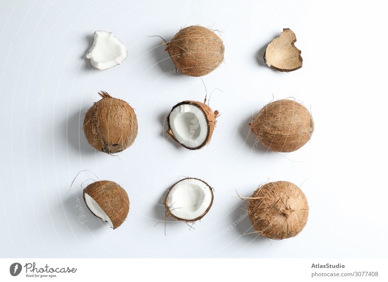 Flachliegende Komposition mit Kokosnüssen auf weißem Hintergrund Hälfte Zusammensetzung Farbe Ton geschnitten Blatt zwei essen modern Handfläche Vegetarier