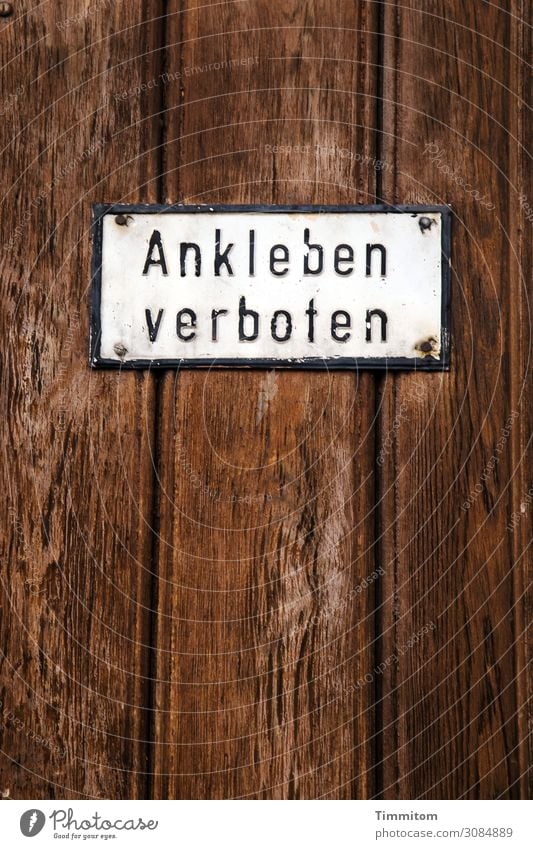 Wegbleiben! Dorf Fassade Holz Metall Schriftzeichen Hinweisschild Warnschild alt braun weiß Garagentor Verbotsschild kleben Farbfoto Außenaufnahme Menschenleer