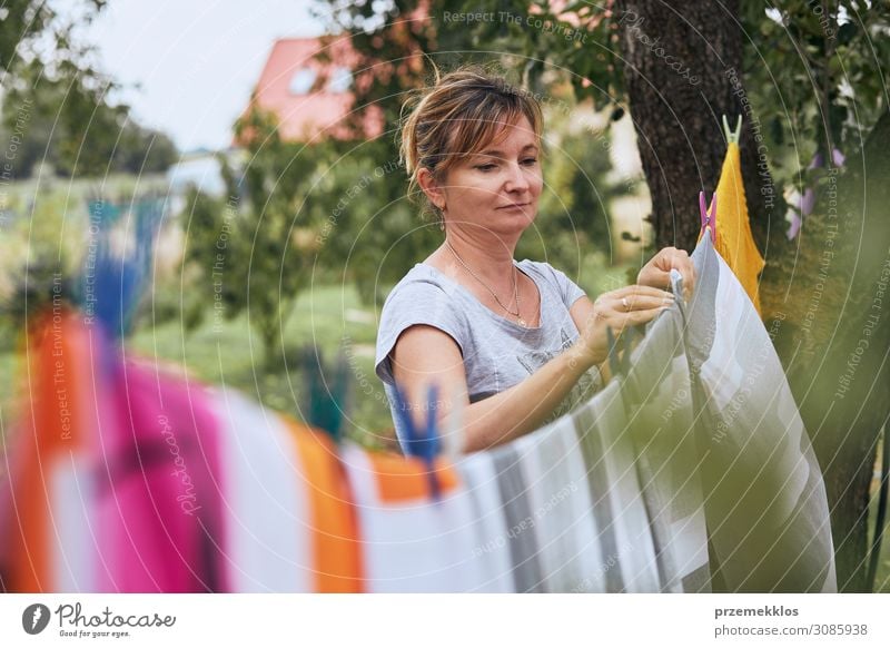 Frau hängend gewaschene Bettwäsche an der Wäscheleine Sommer Garten Arbeit & Erwerbstätigkeit Erwachsene 1 Mensch 45-60 Jahre Bekleidung stehen authentisch