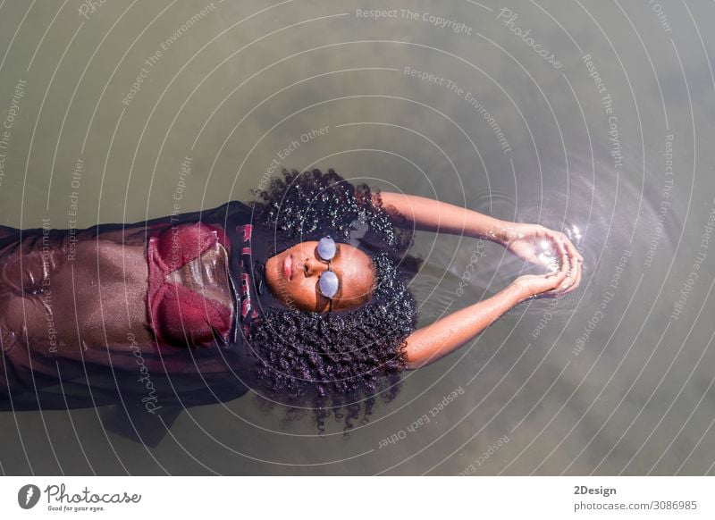 Schöne junge afroamerikanische Frau, die in einem Pool aus Wasser schwimmt. Lifestyle Freude schön Erholung Schwimmbad Freizeit & Hobby Spielen