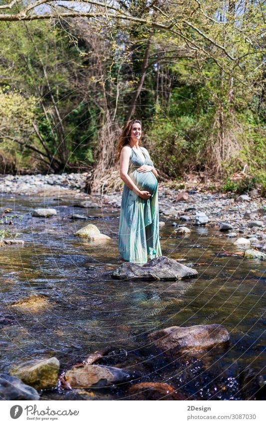 Schwangere Mädchen, die in der Nähe des Flusses posieren und ein grünes Kleid tragen. Lifestyle Stil Freude Glück schön Leben Erholung Freiheit Sommer Meer