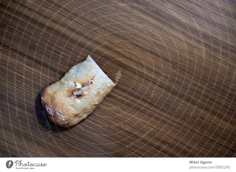 Ein Stück hausgemachtes Brot über dem Küchentisch Lebensmittel Teigwaren Backwaren Ernährung Frühstück Mittagessen Abendessen Tisch Holz dunkel frisch heiß