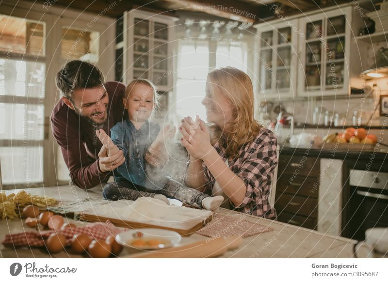 Fröhliches Familienmachen von Nudeln in der Küche Freude Tisch Kind Mensch Mädchen Frau Erwachsene Mann Familie & Verwandtschaft Kindheit 3 Liebe Zusammensein