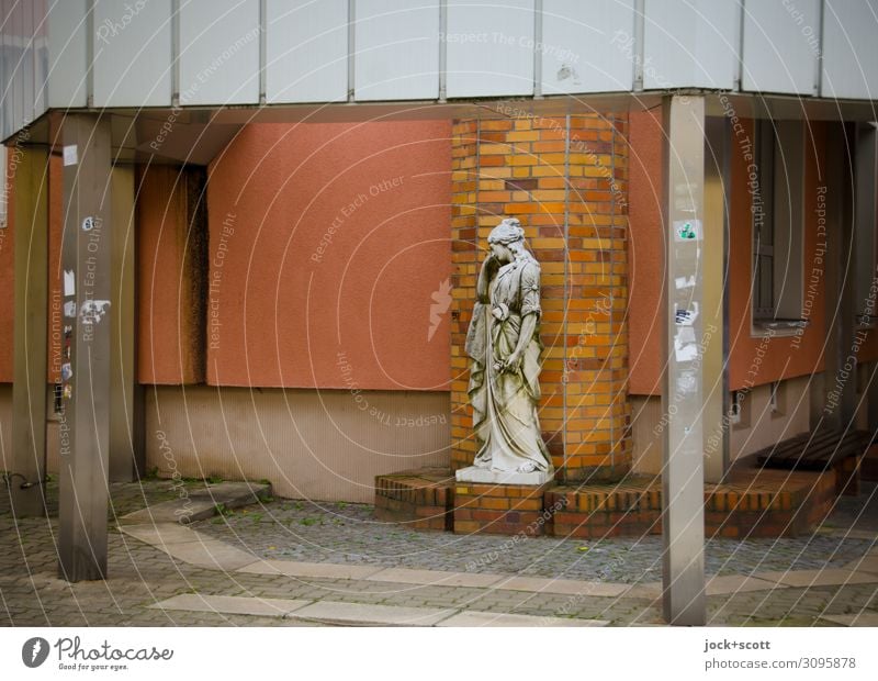 aus der Zeit gefallen Skulptur Stadtzentrum Plattenbau Stadthaus Fassade Vordach Fußgängerzone außergewöhnlich historisch trashig trist Stimmung Romantik