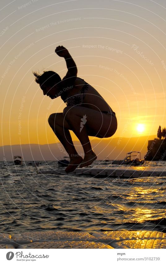 Silhouette von Frau vor Sonnenuntergang, die ins Wasser springt sprung springen See badespaß baden Schwimmen & Baden Sommer Lebensfreude Spaß haben Freude Glück