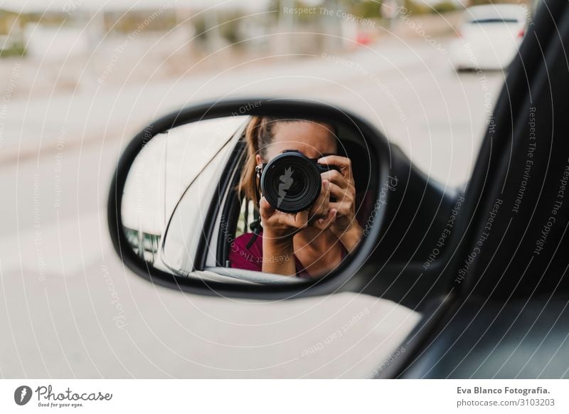 junge Frau, die ein Foto aus dem Rückspiegel eines Autos macht. Reisen und Lebensstil im Freien Freude PKW Ferien & Urlaub & Reisen Verkehr Heck Ausflug