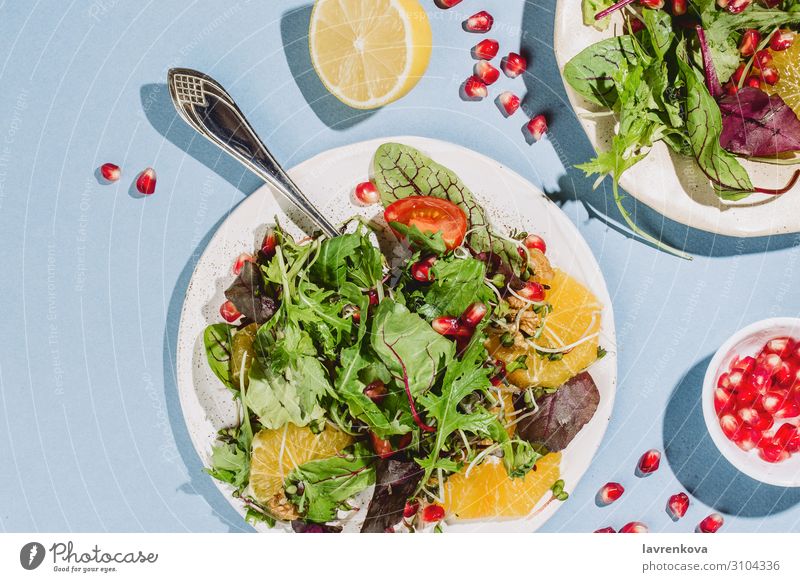 Flachlegung von zwei Zitrussalatplatten Vorspeise Amuse-Gueule Rucola Kirschtomaten Zitrone Zitrusfrüchte Essen zubereiten lecker Diät Abendessen flach