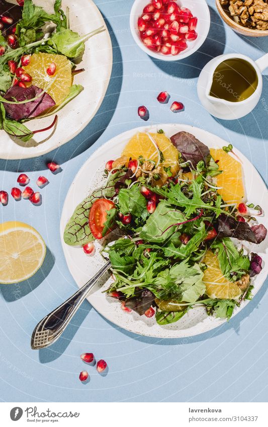 Flachlegung von zwei Zitrussalatplatten Amuse-Gueule Rucola Kirschtomaten Zitrone Zitrusfrüchte Essen zubereiten lecker Diät Abendessen flach Lebensmittel