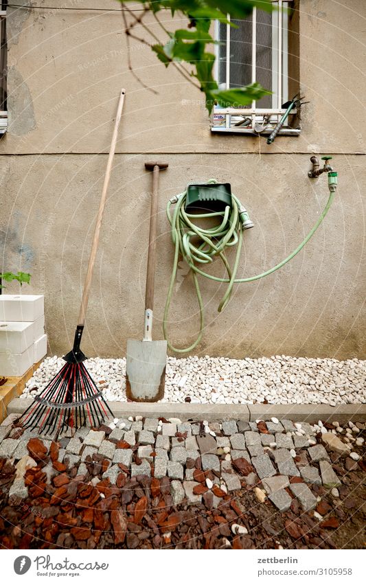 Gartenschlauch Gartengeräte Schlauch Wasser Wasserhahn Wasserschlauch Spaten Schaufel Häusliches Leben Wohnhaus Fassade Fenster Gitter Kies Menschenleer