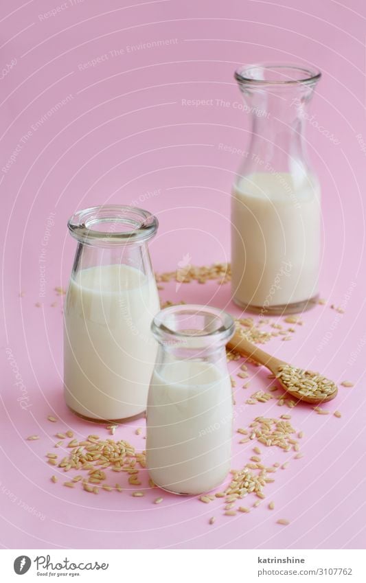 Vegane Reismilch, milchfreie Alternativmilch Gemüse Ernährung Frühstück Vegetarische Ernährung Diät Getränk Flasche Löffel Tisch frisch natürlich rosa weiß