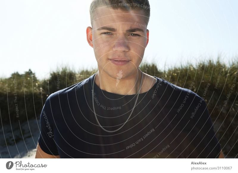 Gegenlichtportrait eines jungen Mannes vor einer Stranddüne Freude schön harmonisch Wohlgefühl Sommer Sommerurlaub Sonne Düne Junger Mann Jugendliche