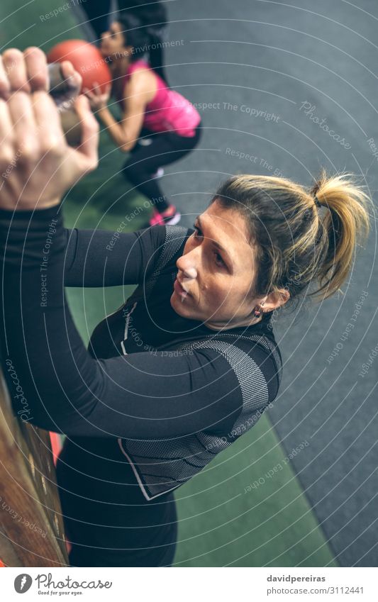 Frau, die an der Stecktafel hängt. Lifestyle Körper Sport Mensch Erwachsene Hand Fitness sportlich authentisch dünn stark Kraft Sportlerin durchkreuzen passen