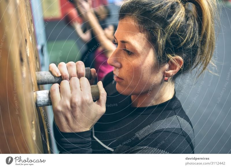 Frau, die an der Stecktafel hängt. Lifestyle Körper Sport Mensch Erwachsene Hand Fitness sportlich authentisch stark Kraft Steckplatte aufhängen durchkreuzen