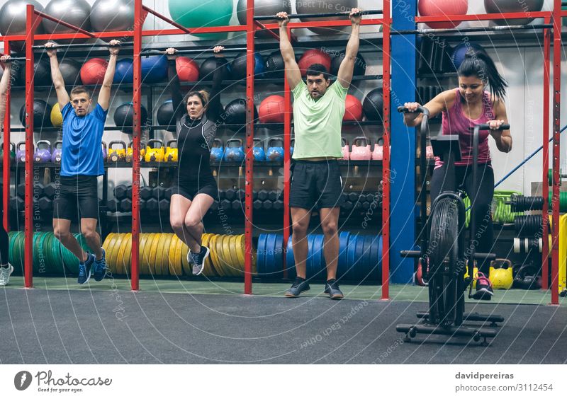 Athleten, die Pull-Ups machen und Airbike in der Turnhalle. Lifestyle Sport Ball Mensch Frau Erwachsene Mann Menschengruppe Fitness authentisch Klimmzüge