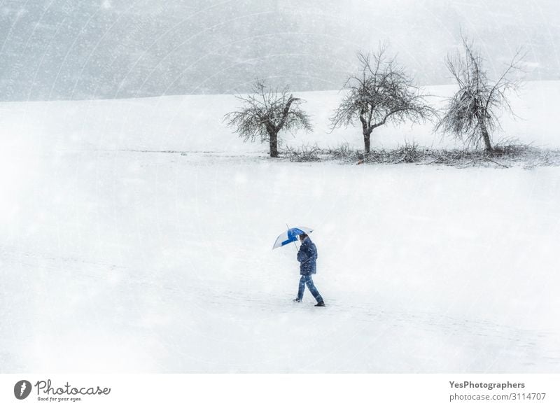 Schneesturmlandschaft. Mann geht durch den Schneefall. Winterwetter wandern Erwachsene Natur Klimawandel schlechtes Wetter Unwetter Sturm weiß Einsamkeit