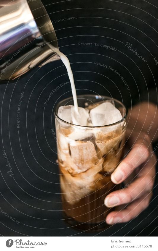 Frau gießt Milch in eisgekühlten Schokoladenespresso. Kaffeetrinken Getränk Erfrischungsgetränk Espresso Lifestyle Freude Mensch feminin Finger 1 genießen kalt