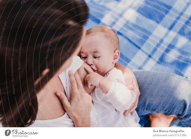 junge Mutter stillen, die ihr kleines Mädchen im Freien in einem Park füttert. Essen Lifestyle Freude schön Sommer Sonne Kindererziehung feminin Baby Junge Frau