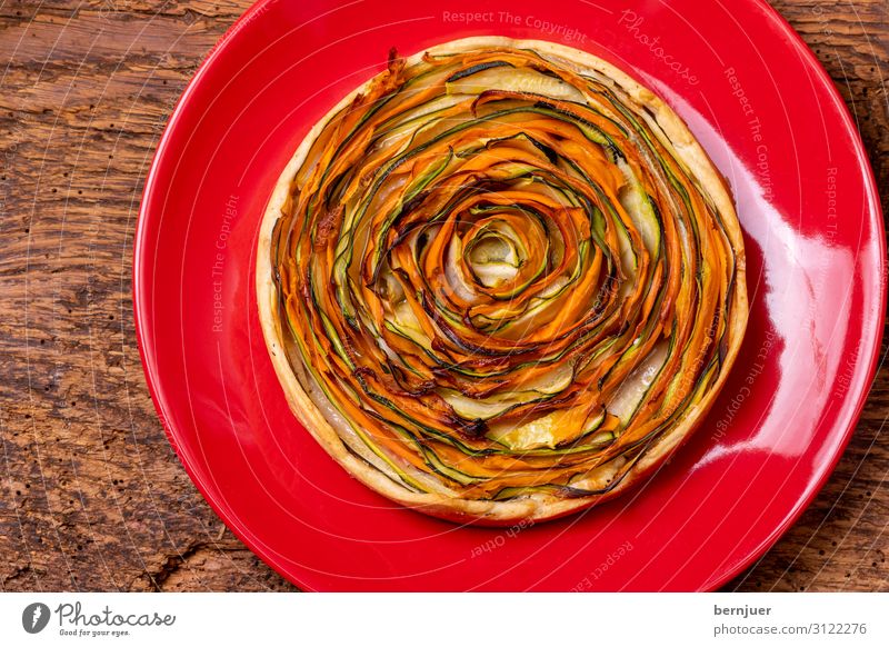 Kuchen mit Karotten und Zucchini Joghurt Gemüse Brot Ernährung Mittagessen Abendessen Vegetarische Ernährung Teller Papier Holz rund grün Quiche Schiffsplanken