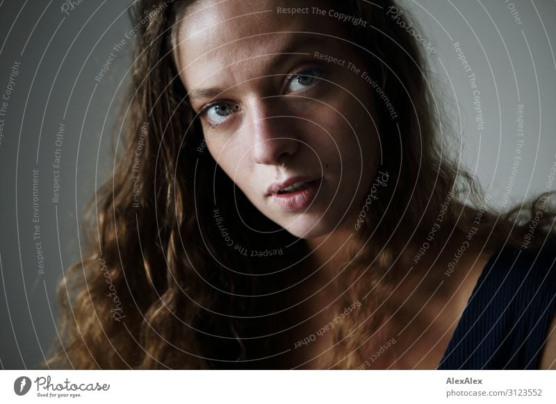 Portrait einer jungen Frau mit lockigen, brünetten Haaren Lifestyle Reichtum Stil Freude schön Sinnesorgane Junge Frau Jugendliche Haare & Frisuren Gesicht