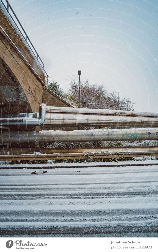 Weitwinkel Industrie Winterlandschaft mit Schneeflocken Straße Aquädukt Brücke kalt Freiheit gefroren industriell Außenaufnahme Eisenrohr Schneefall Vorstadt