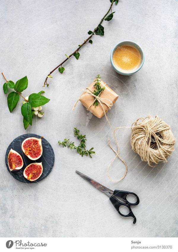 Weihnachtlich verpacktes Geschenk mit einer Tasse Kaffee Frucht Feige Getränk Heißgetränk Espresso Teller Lifestyle Stil Weihnachten & Advent Geburtstag Efeu