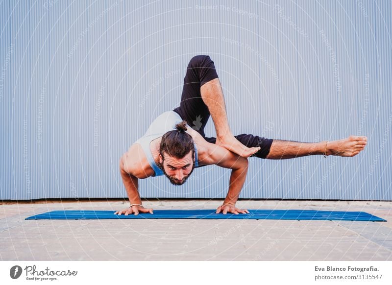 mann in der stadt, der yoga-sport betreibt. blauer hintergrund. gesunde lebensweise Blauer Hintergrund Yoga Mann Großstadt Stadt Lifestyle muskulös