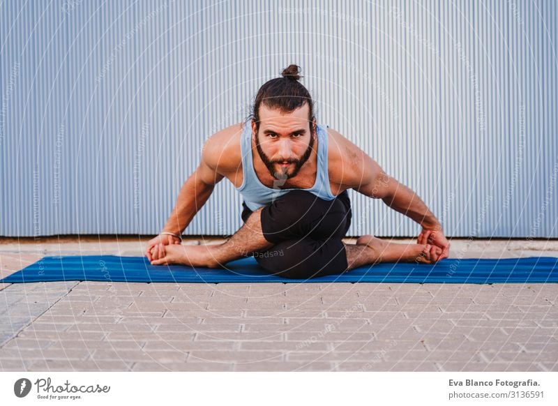 mann in der stadt, der yoga-sport betreibt. blauer hintergrund. gesunde lebensweise Yoga Mann Sport Gesundheit Außenaufnahme Großstadt Blauer Hintergrund