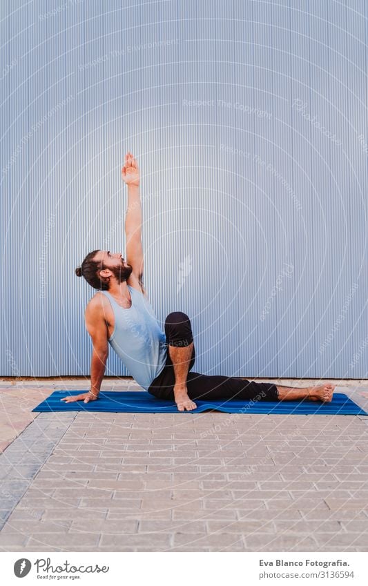 mann in der stadt, der yoga-sport betreibt. blauer hintergrund. gesunde lebensweise Yoga Mann Sport Gesundheit Außenaufnahme Großstadt Blauer Hintergrund