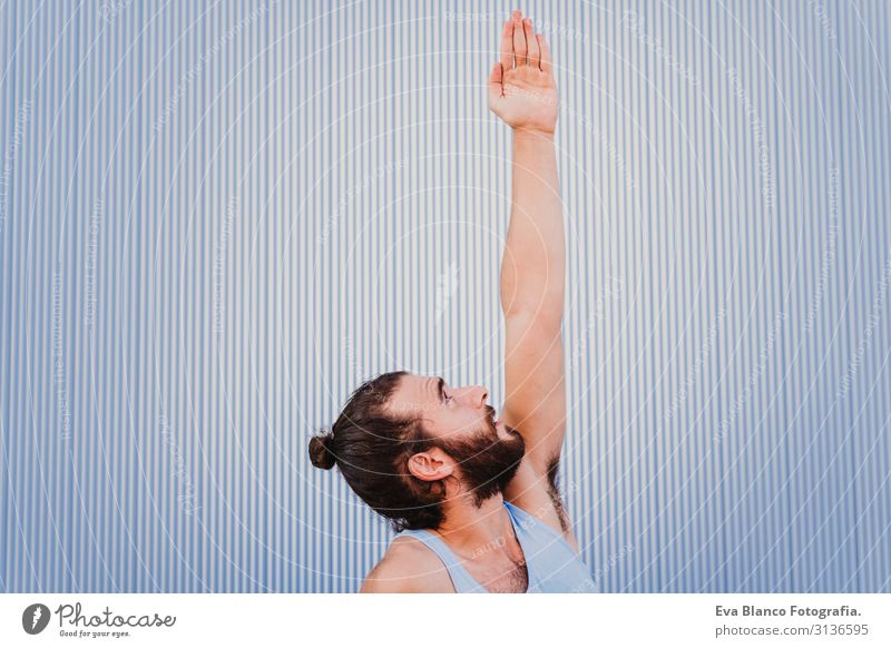 mann in der stadt, der yoga-sport betreibt. blauer hintergrund. gesunde lebensweise Yoga Mann Sport Gesundheit Außenaufnahme Großstadt Blauer Hintergrund