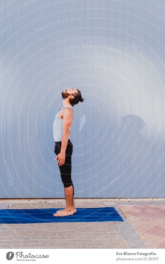 mann in der stadt, der yoga-sport betreibt. blauer hintergrund. gesunde lebensweise Yoga Mann Sport Gesundheit Außenaufnahme Großstadt Blauer Hintergrund