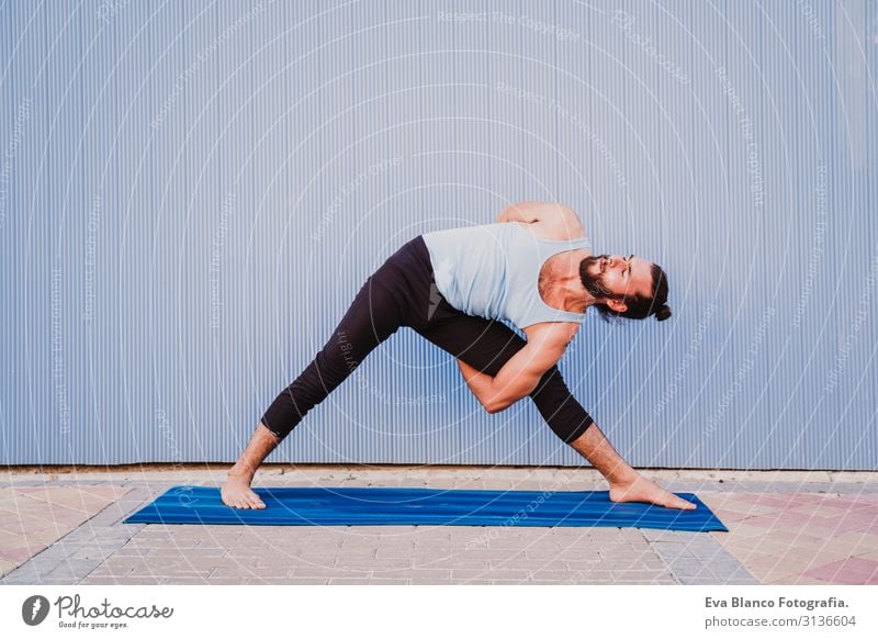 mann in der stadt, der yoga-sport betreibt. blauer hintergrund. gesunde lebensweise Yoga Mann Sport Gesundheit Außenaufnahme Großstadt Blauer Hintergrund