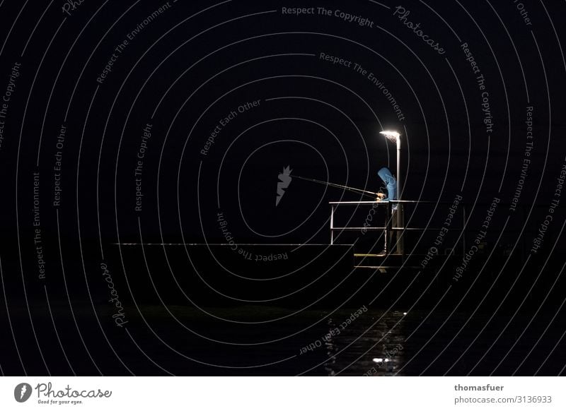 Angler bei Nacht Angeln Angelrute Mensch maskulin 1 Natur Wasser Nachthimmel Küste Brücke Anlegestelle Jacke Kaputze Lampe Lampenlicht Brückengeländer dunkel