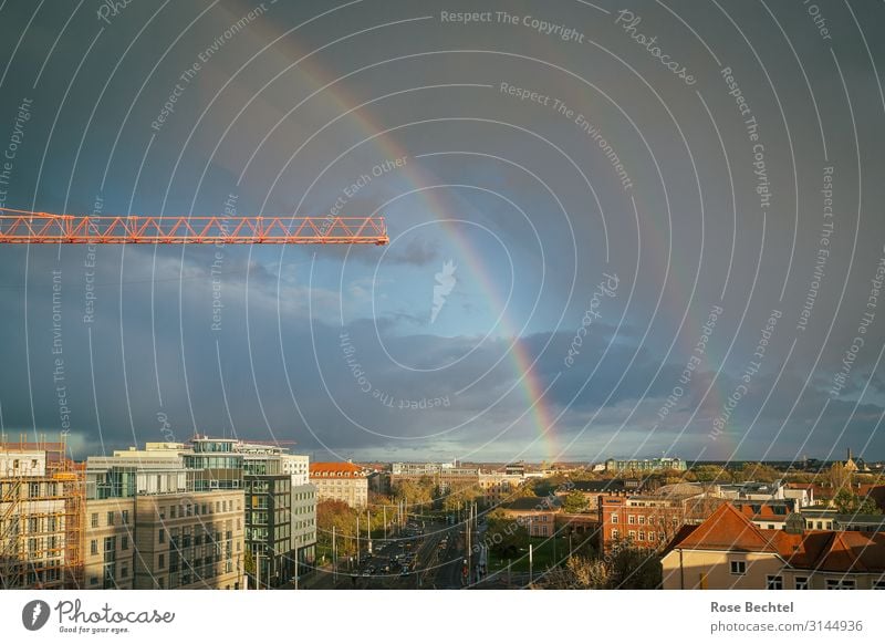 Regenbogen mit Kran Gewitterwolken Herbst schlechtes Wetter Stadt Skyline Haus bauen blau orange Häusliches Leben Leipzig Baukran Wohnungsbau Farbfoto